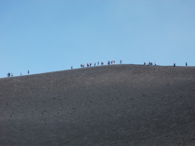 Fila turisti sulle oendici dell'Etna